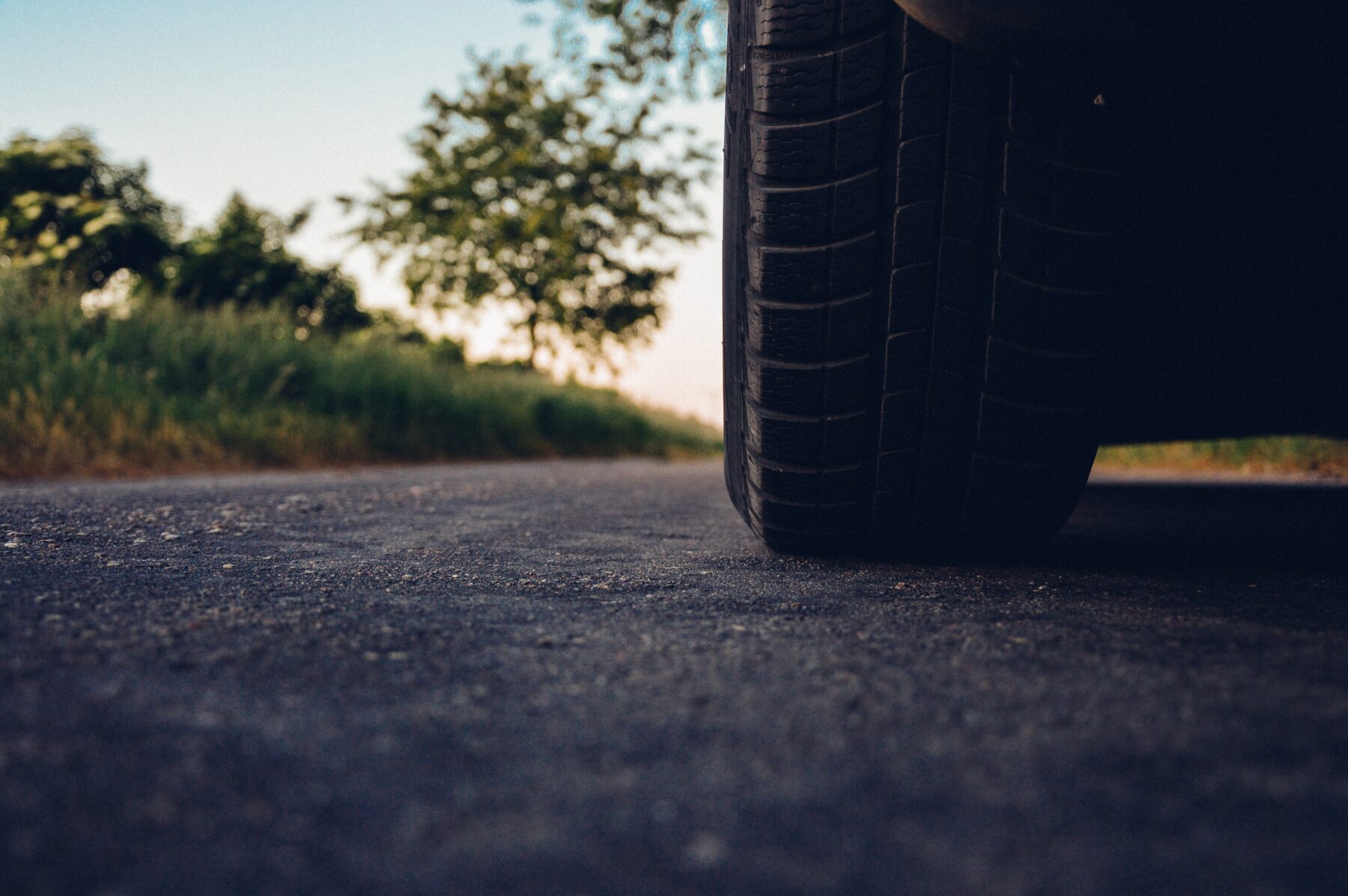 Car tire driving over cold mix asphalt pavement