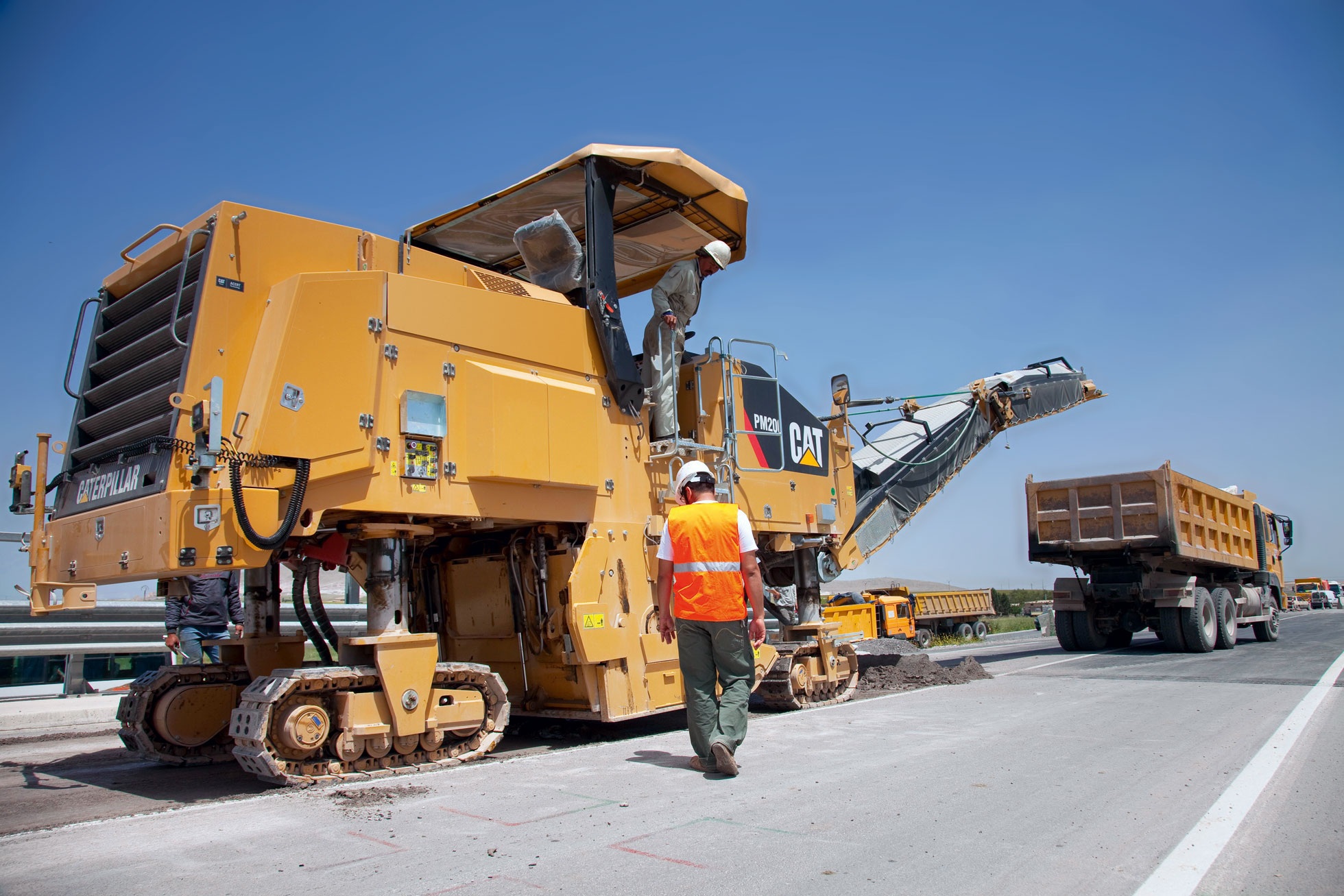 Asphalt milling machine in action, removing old pavement layers to prepare for resurfacing and road restoration.