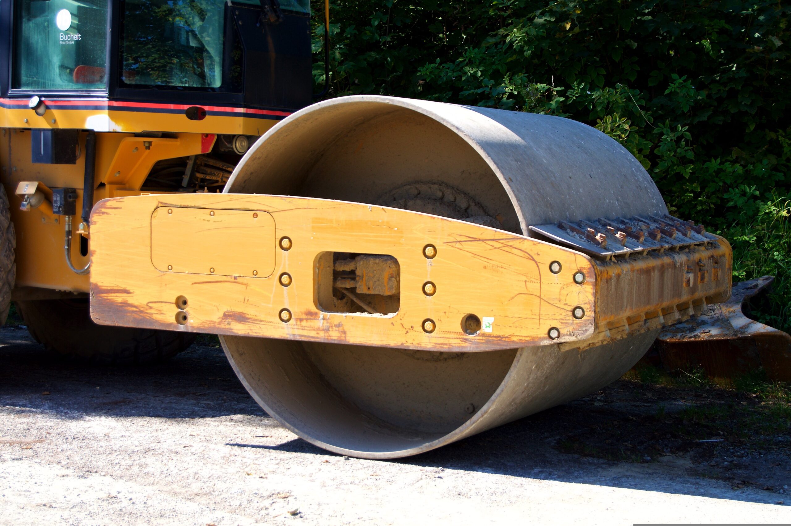 Heavy-duty road roller compacting gravel during a road grading project in Omaha