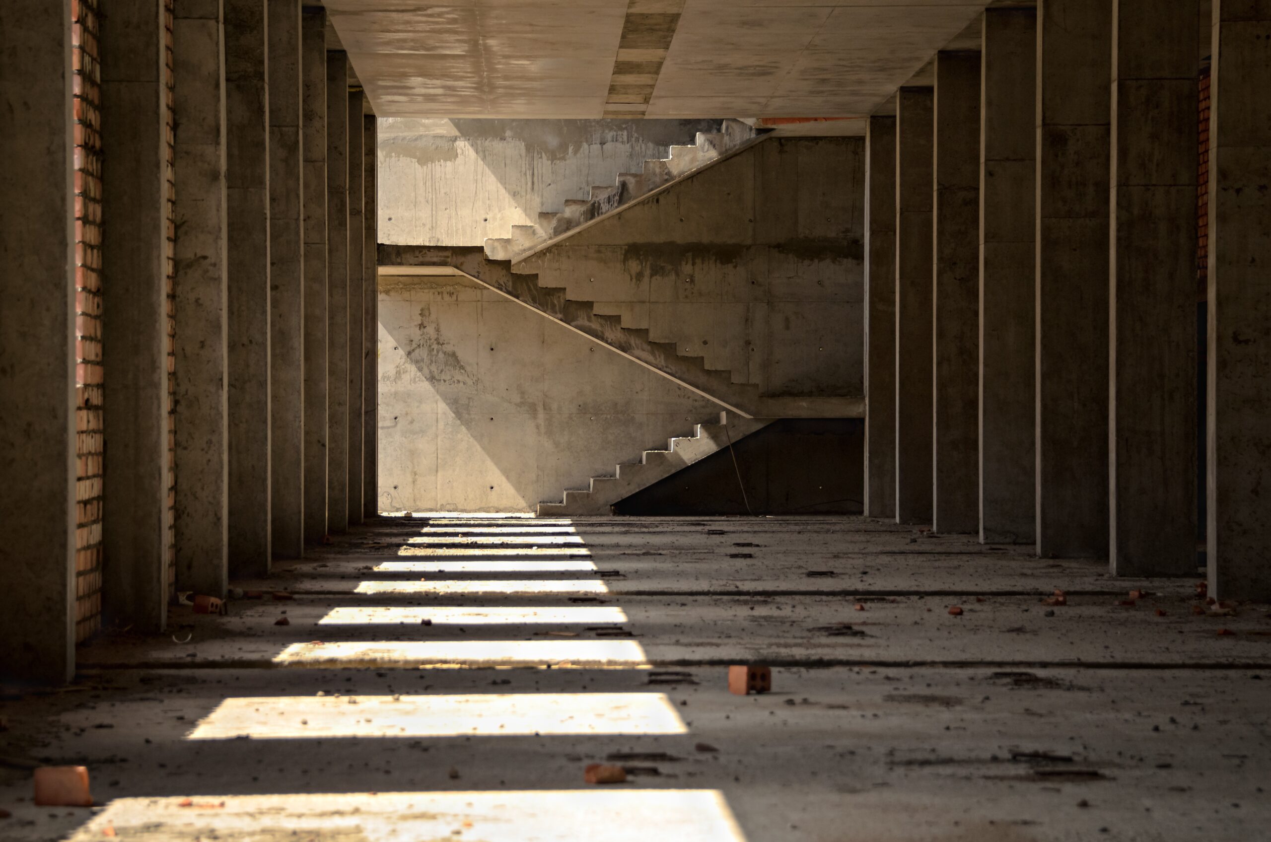 Interior of a concrete structure with columns and staircase, representing environments where smart sensors monitor concrete strength.