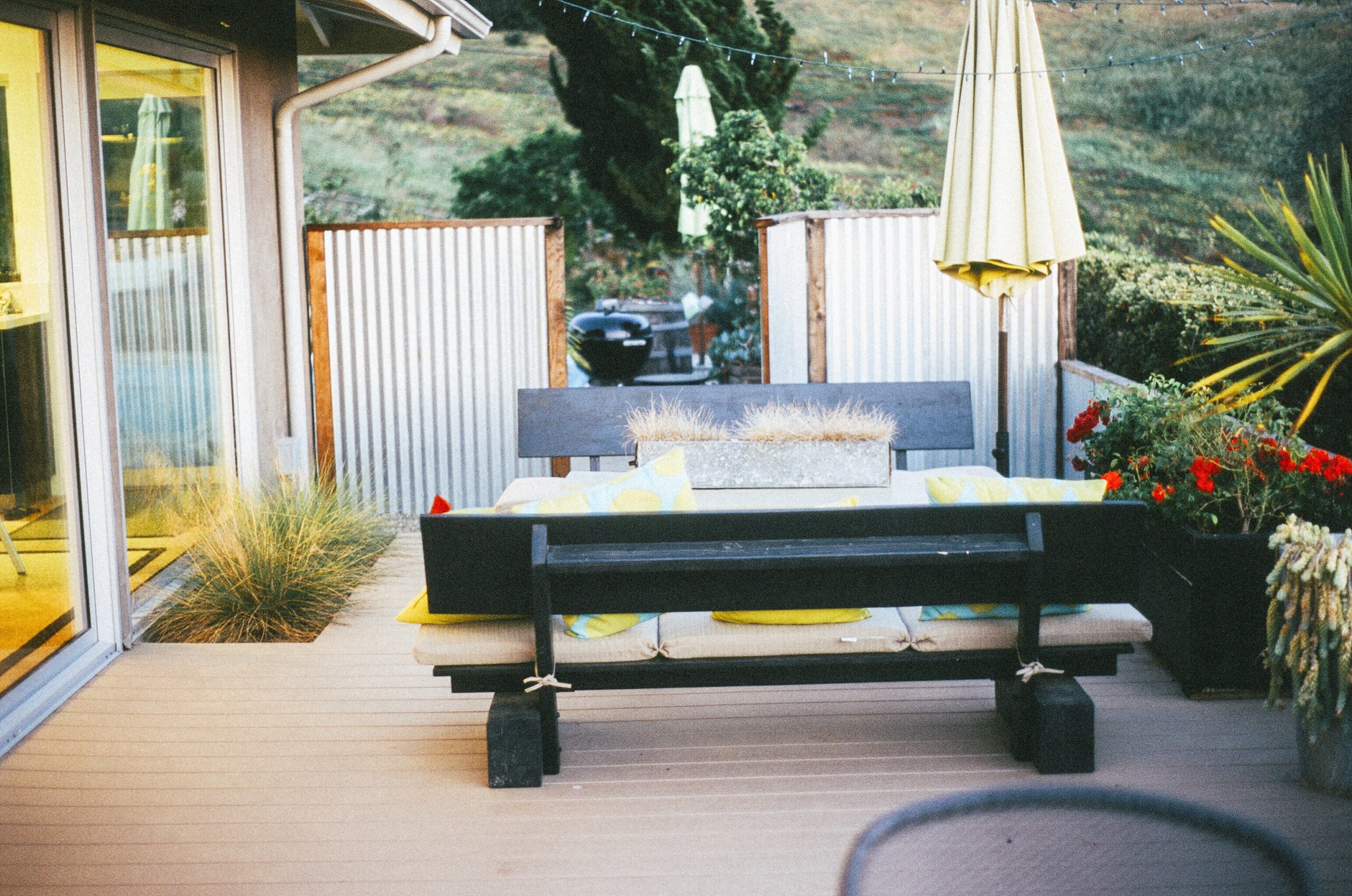 Backyard patio with umbrella, bench, and blended stone-concrete flooring
