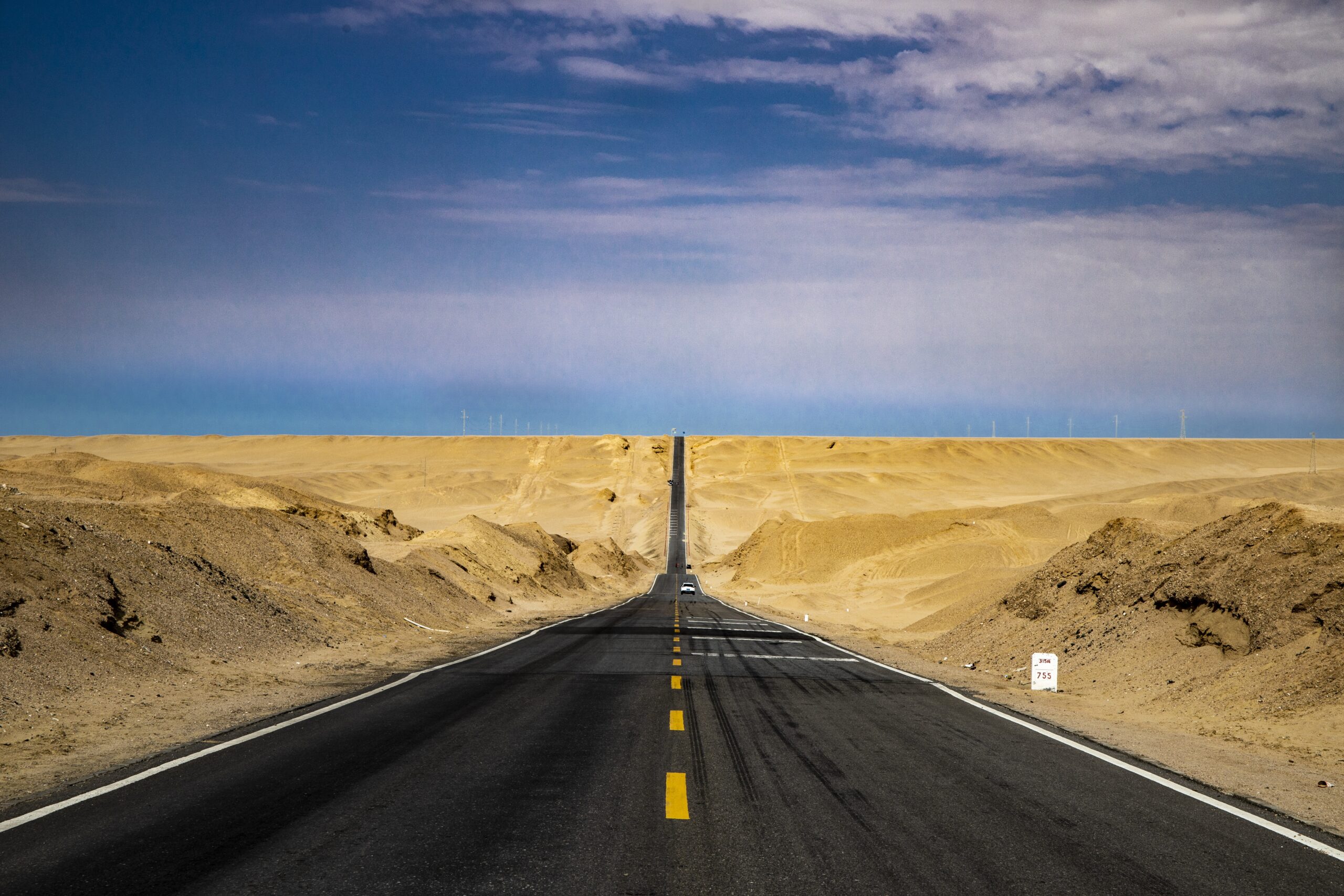 Asphalt road in hot desert conditions showing how summer heat contributes to rutting and pavement damage